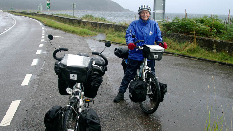 Zwei Räder und Radlerin in Regenklamotten