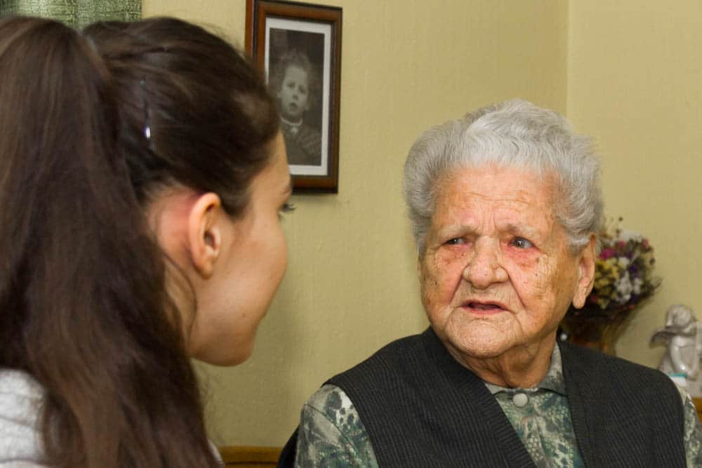eine alte Frau schaut ein junges Mädchen intensiv an