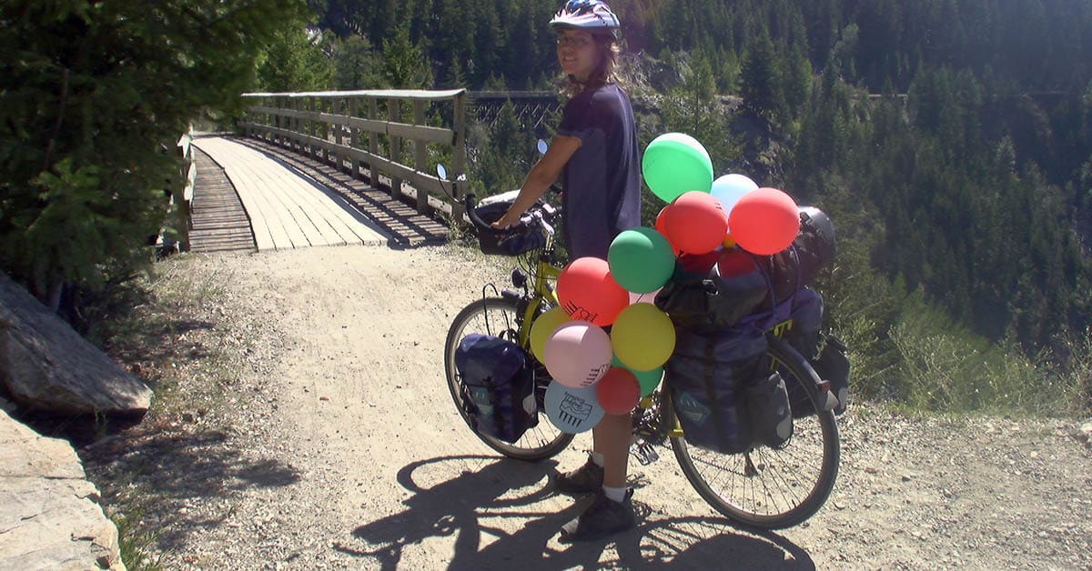 vollbeladenes Reiserad mit bunten Luftballons die die Packtaschen verdecken