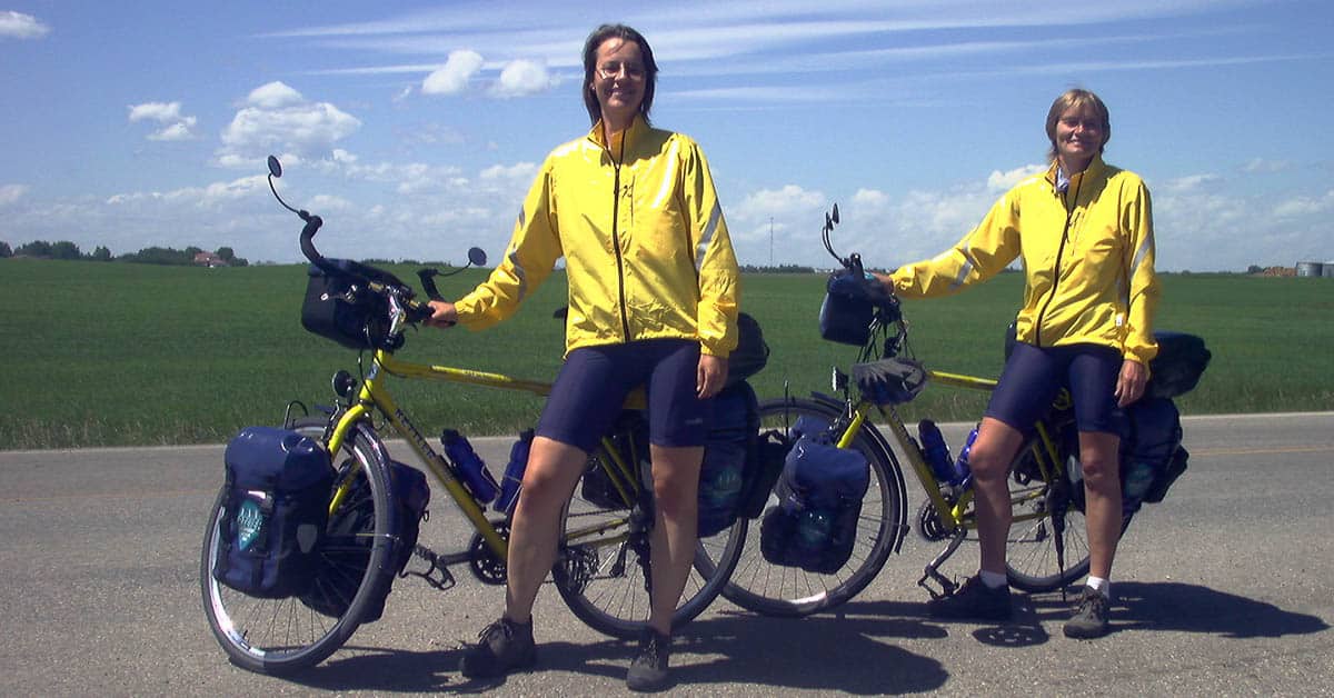 Beate Steger und Carol Streeter beide in gelben Radklamotten mit ihren Rädern auf einer Strasse in Kanada