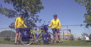 Beate Steger und Carol Streeter beide in gelben Radklamotten mit ihren Rädern auf einer Strasse in Kanada